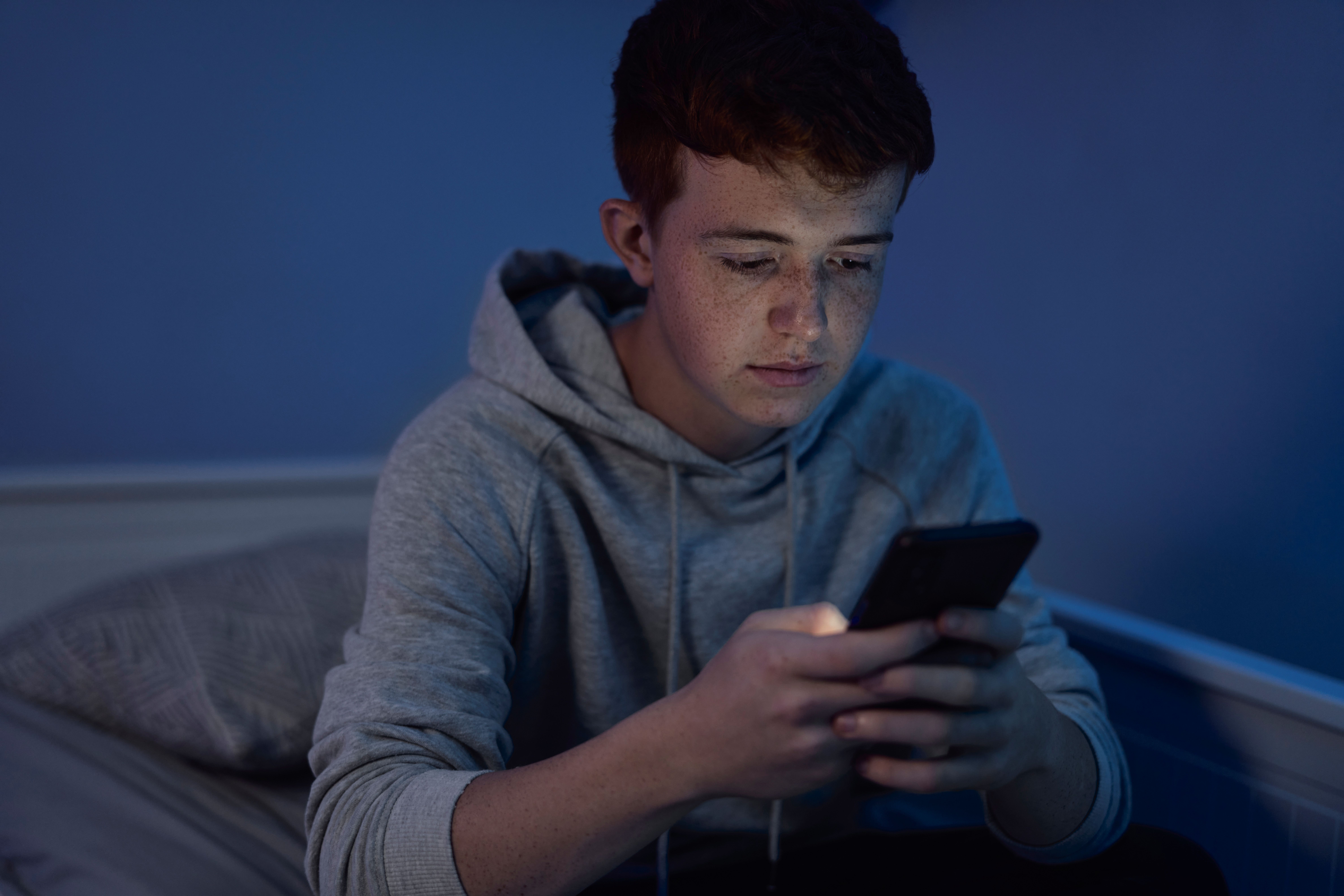 teenage-boy-in-hoodie-using-a-mobile-phone-2026-01-06-09-28-31-utc.jpg